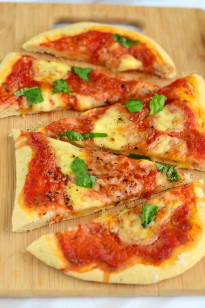 istock Homemade pizza with tomatoes, mozzarella and basil served on wooden board 1027049202