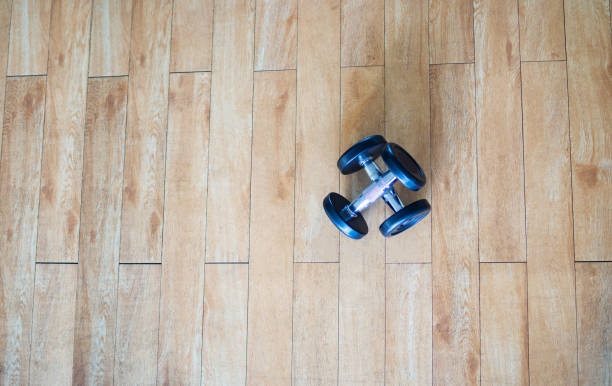 istock Dumbbells on the gym wooden floor 1027051652