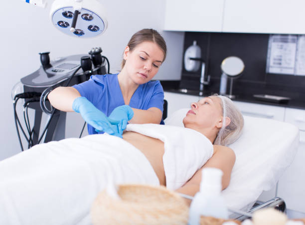 istock Cosmetologist examining mature female body 1027052590