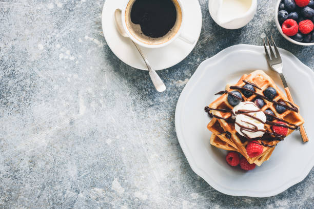 istock Belgian waffles with ice cream, berries and cup of coffee 1027056608