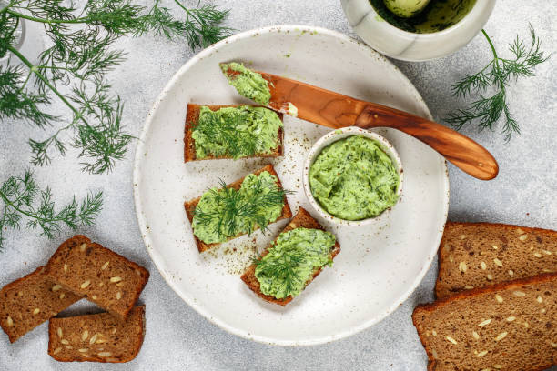 istock Delicious appetizer - butter with dill greens on rye bread with sunflower seeds 1027062366
