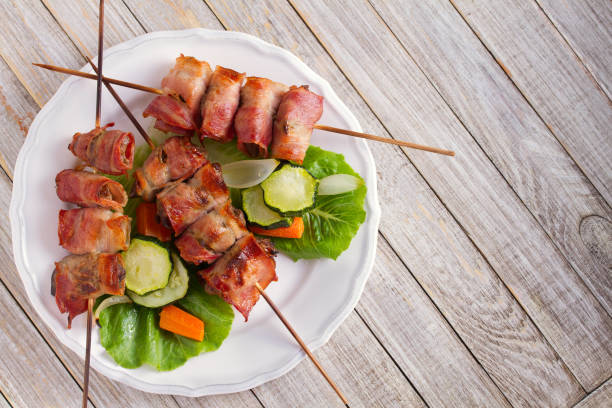 istock Chicken liver wrapped with bacon on skewers. Grilled liver kebabs with vegetables 1027062920