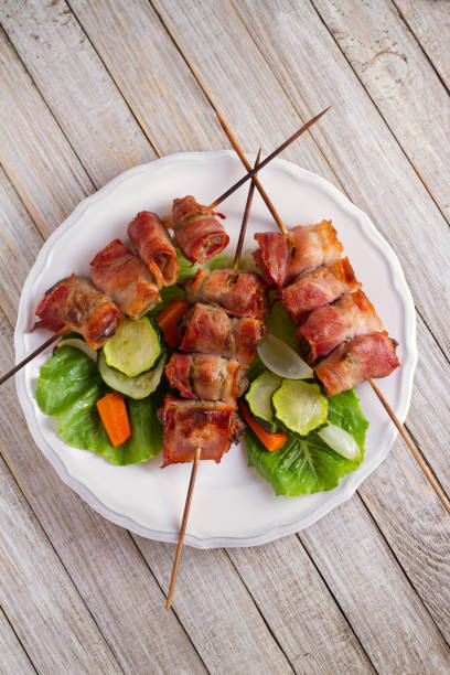 istock Chicken liver wrapped with bacon on skewers. Grilled liver kebabs with vegetables 1027063066