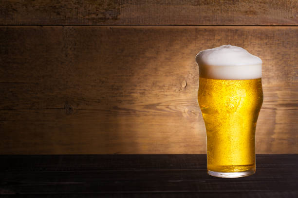istock Glass of beer on wooden background with copyspace for text 1027069564