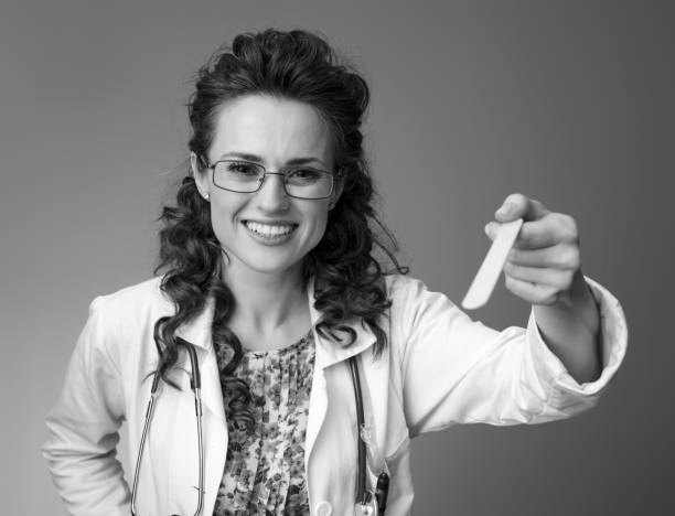 istock paediatrician doctor using spatula to examine throat on 1027079458