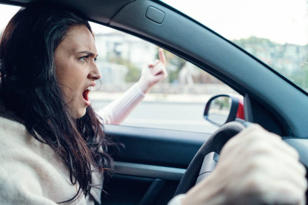 istock Female driver yelling and showing rude gesture 1027086088