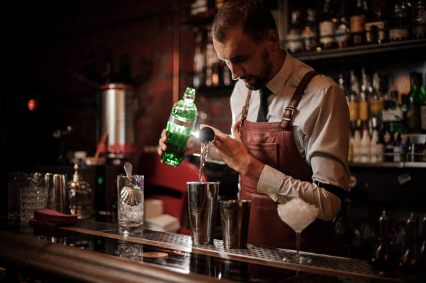 barista versando un alcol dal misurino nello shaker d'acciaio - cocktail transparent cocktail shaker glass foto e immagini stock