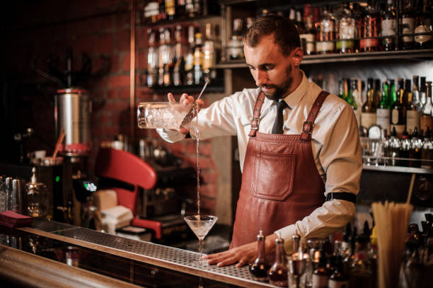 istock Bartender pouring a cocktail into the cocktail glass 1027093324
