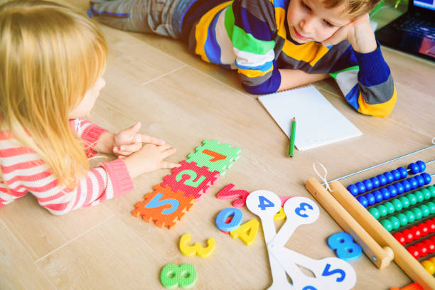 istock little boy and girl learn to write and calculate numbers 1027093934