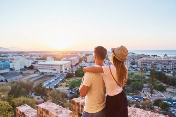 istock Happy young couple of travellers watching sunset 1027097328