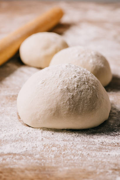 istock selective focus of raw dough for pizza and rolling pin on tabletop 1027100940