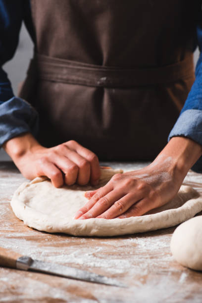 istock partial view of woman in apron kneading dough for pizza 1027101010