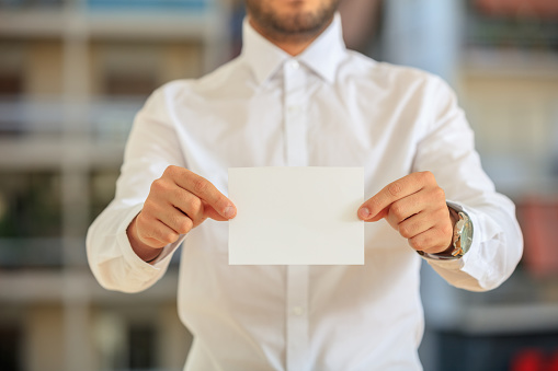 Businessman holding a white card