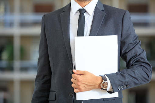 Manager in suit holding documents