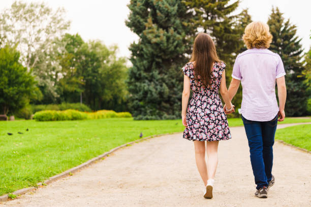istock Man and woman holding hands in park 1027104812