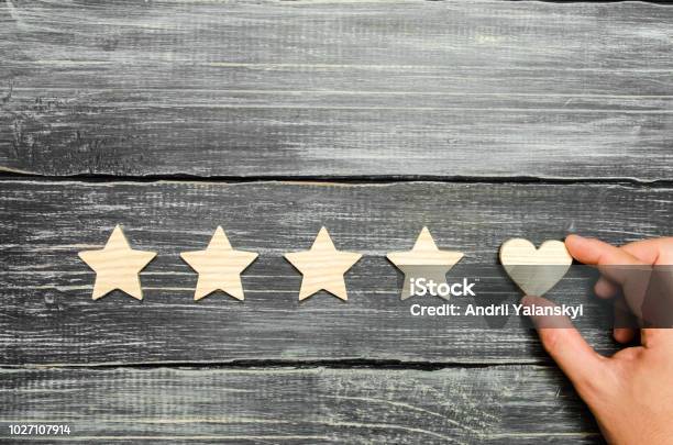 The Hand Puts The Heart To The Four Stars Choice Of Buyers Universal Recognition And Admiration Rating Of A Hotel Or Restaurant Product Or Mobile Application Increase In Rating And Prestige Stock Photo - Download Image Now