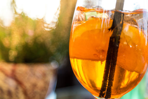 Close up color image depicting a freshly prepared Spritz cocktail outdoors on a table. Room for copy space.