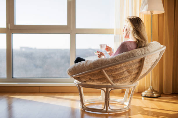 istock Woman sitting in chair and drinking tea 1027111478
