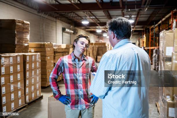 Ein Lagerleiter Spricht Mit Einem Jüngeren Lagerarbeiter Stockfoto und mehr Bilder von Employee