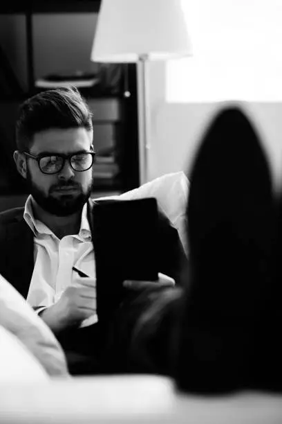 Serious businessman making notes on sofa