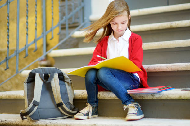 istock Adorable little schoolgirl studying outdoors on bright autumn day. Young student doing her homework. Education for small kids. 1027125720