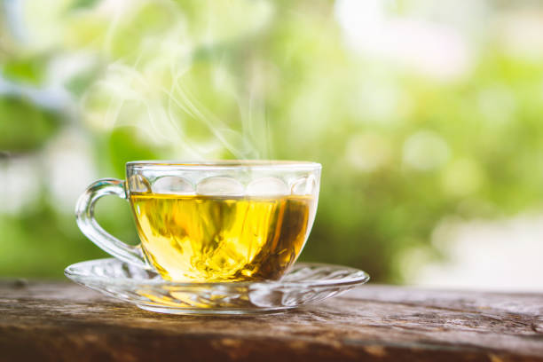 istock hot tea cup on wooden table with background of nature sunlight 1027132392