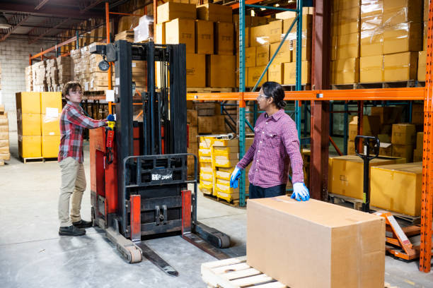 istock Two warehouse workers preparing to lift a heavy box together 1027132664