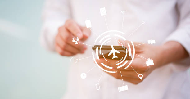 close up man hand using smartphone for booking travel with virtual interface of air transportation symbol technology or business  concept