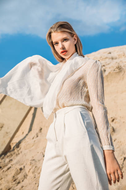 istock attractive blonde model with white silk scarf posing in desert 1027136266
