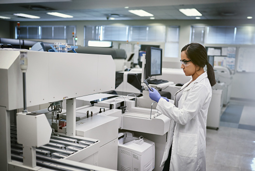 A female scientist controls the operation of devices for laboratory research. Modern laboratory technologies. Medical research centrifuge.