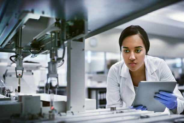 She finds the answers to life’s mysteries Shot of a young woman using a digital tablet while working in a laboratory biochemist stock pictures, royalty-free photos & images