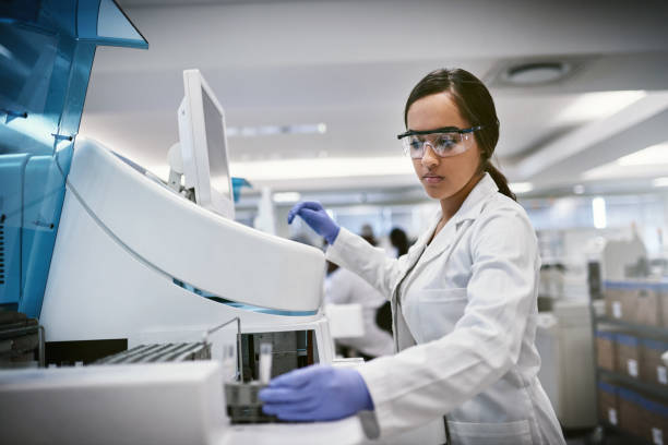 There’s always something waiting to be discovered Shot of a young woman using a machine to conduct a medical test in a laboratory medication stock pictures, royalty-free photos & images