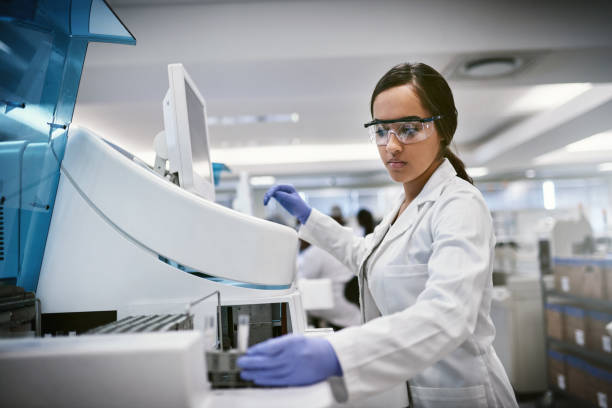 There’s always something waiting to be discovered Shot of a young woman using a machine to conduct a medical test in a laboratory biology stock pictures, royalty-free photos & images