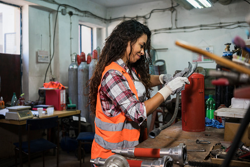 Woman repairing fire extinguisher at workshop