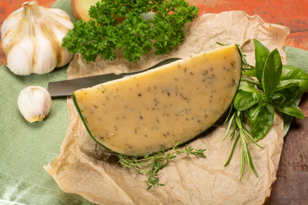 fromage à pâte dure spécialité néerlandaise fait de lait de vaches avec différentes épices et herbes vertes fraîches - basiron photos et images de collection