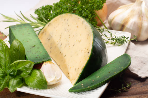 fromage à pâte dure spécialité néerlandaise fait de lait de vaches avec différentes épices et herbes vertes fraîches - basiron photos et images de collection