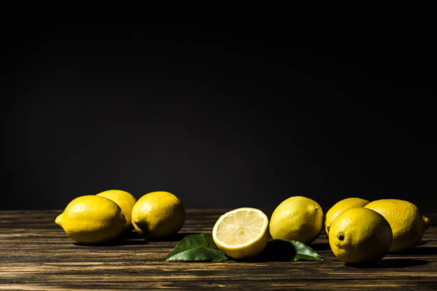 istock juicy yellow lemons on wooden table with black background 1027144994