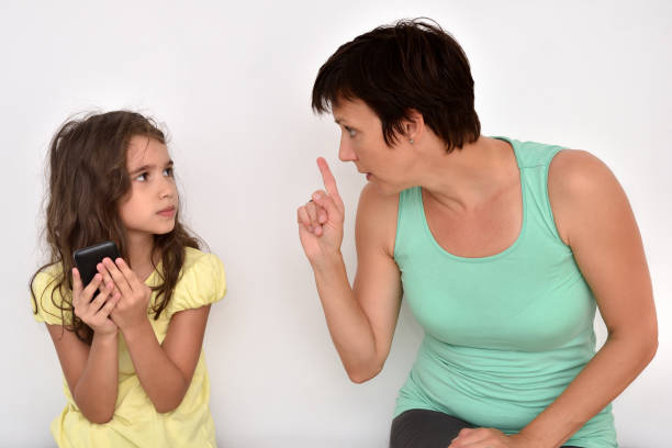 istock Angry mother scolding her daughter with smartphone 1027145524