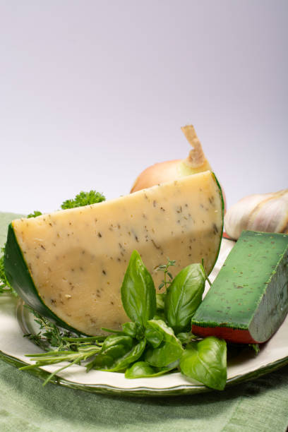 fromage à pâte dure spécialité néerlandaise fait de lait de vaches avec différentes épices et herbes vertes fraîches - basiron photos et images de collection