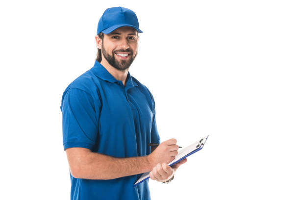 istock happy young delivery man writing on clipboard and smiling at camera isolated on white 1027153968