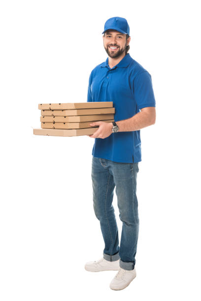 pełna długość widok szczęśliwego kuriera trzymającego pudełka z pizzą i uśmiechającego się do kamery odizolowanej na białym - box men holding isolated zdjęcia i obrazy z banku zdjęć