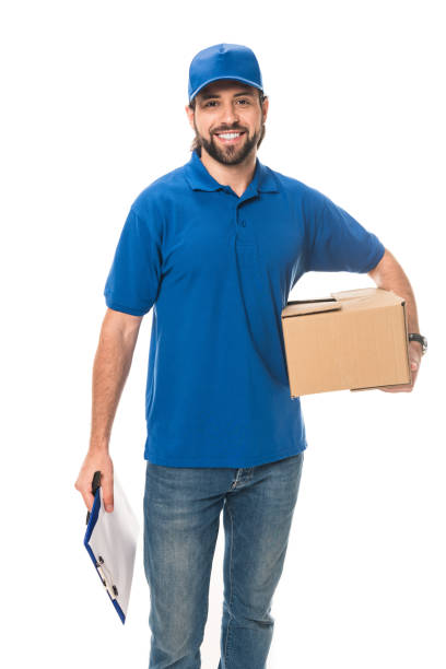 istock smiling young delivery man holding cardboard box and blank clipboard isolated on white 1027154070