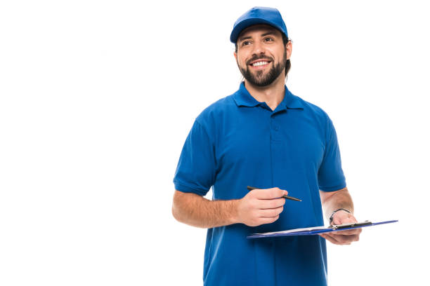 istock handsome happy delivery man writing on clipboard and looking away isolated on white 1027154142