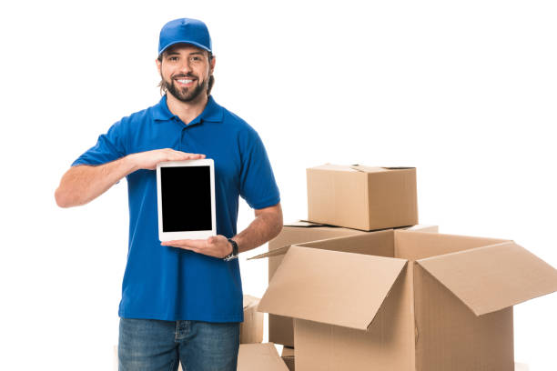 istock handsome delivery man holding digital tablet with blank screen and smiling at camera isolated on white 1027154674