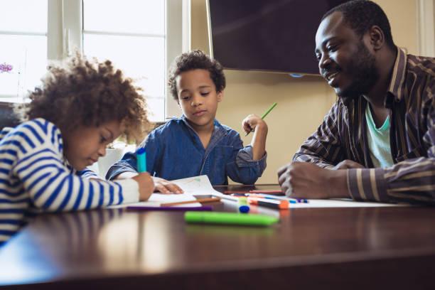 istock Father and his children doing homework at home 1027161208