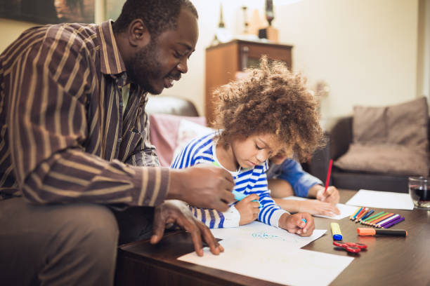 istock Father and his children doing homework at home 1027161270