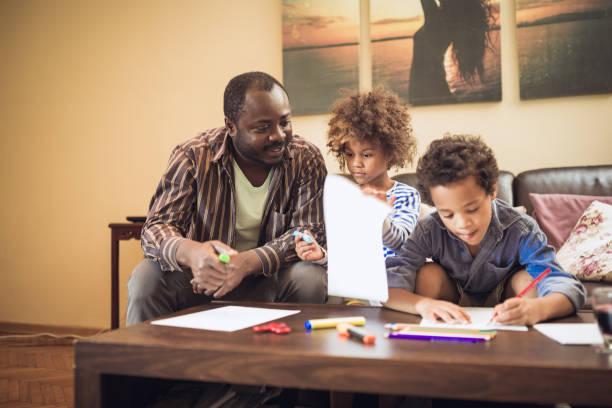 istock Father and his children doing homework at home 1027161362