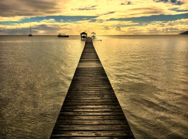 sunset beach pier - french polynesia pier lagoon nautical vessel - fotografias e filmes do acervo