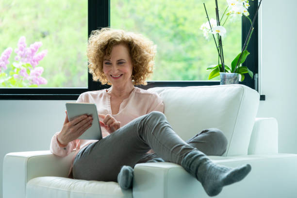 istock Woman in chair with feet up plus tablet 1027161610