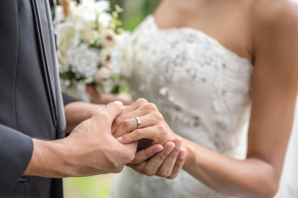 istock Groom wears a wedding ring to the bride finger. Wedding is a commitment to love and take care each other. 1027166006